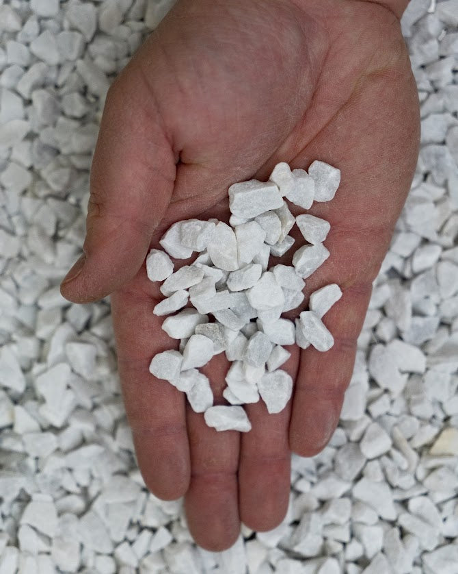 Mano con Granulato di marmo bianco di Carrara